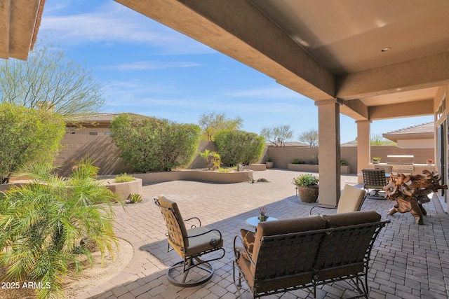 view of patio with a fenced backyard, grilling area, and exterior kitchen