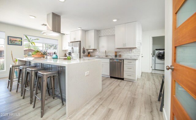 2320 E Mulberry Dr, Phoenix, AZ 85016 - kitchen with light wood-style flooring, backsplash, a breakfast bar, and stainless steel appliances