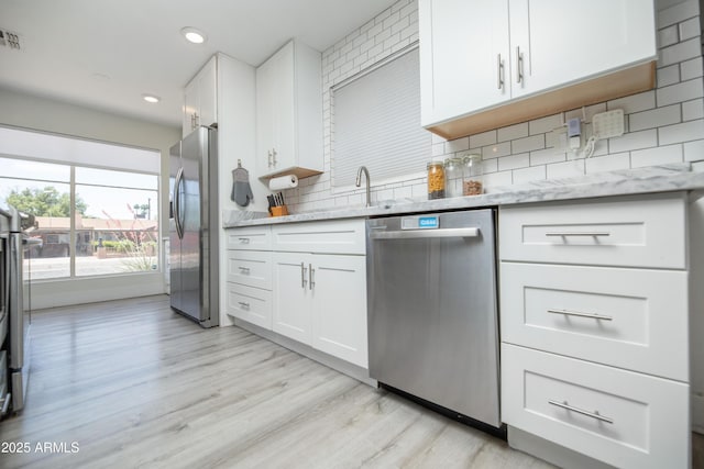 2320 E Mulberry Dr, Phoenix, AZ 85016 - kitchen with light stone countertops, white cabinetry, tasteful backsplash, light wood-style flooring, and appliances with stainless steel finishes