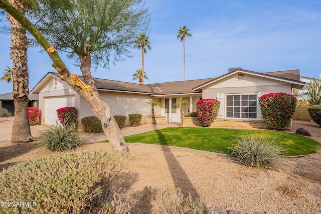 ranch-style house featuring a garage and a front lawn