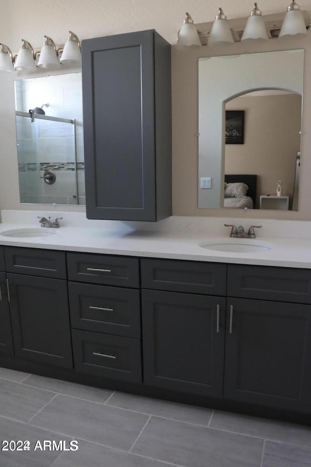 bathroom featuring tile patterned flooring, vanity, and walk in shower