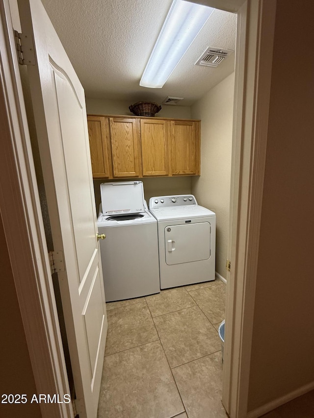 3891 E Simpson Rd, Gilbert, AZ 85297 - laundry room with cabinet space, washing machine and clothes dryer, a textured ceiling, and light tile patterned floors