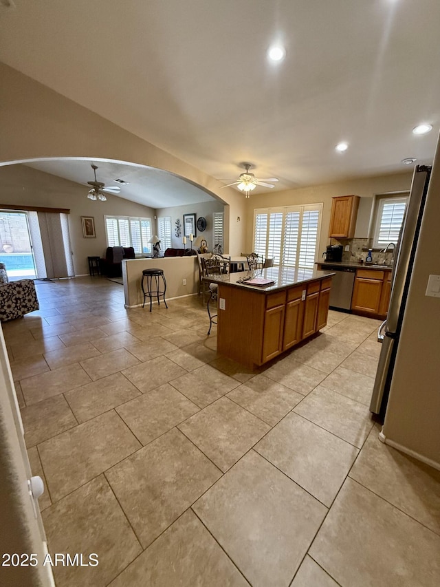 3891 E Simpson Rd, Gilbert, AZ 85297 - kitchen with a ceiling fan, stainless steel appliances, open floor plan, a breakfast bar, and arched walkways