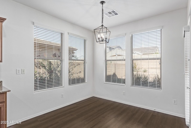 unfurnished dining area featuring dark wood-type flooring and a chandelier