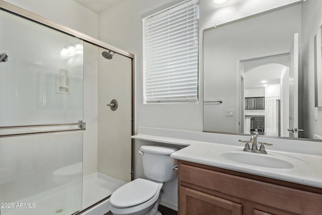 bathroom with walk in shower, vanity, and toilet