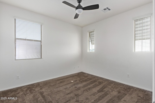 empty room featuring dark colored carpet and ceiling fan