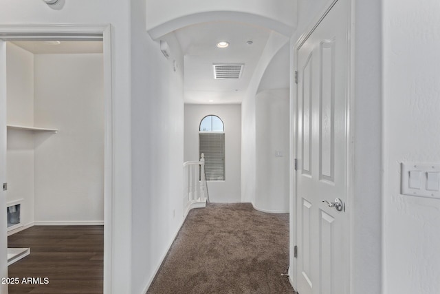 corridor featuring dark colored carpet