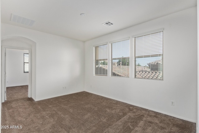 unfurnished room with dark colored carpet