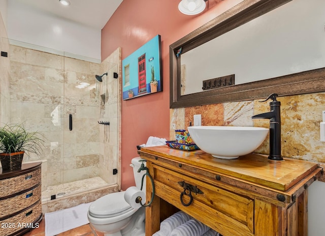 bathroom featuring a shower stall, toilet, and vanity
