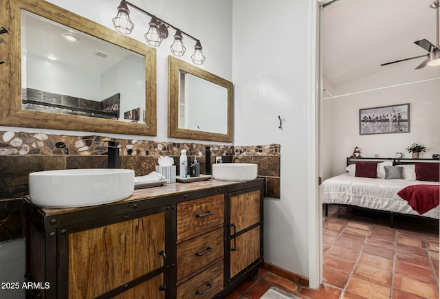 bathroom with a ceiling fan, double vanity, a sink, and ensuite bathroom