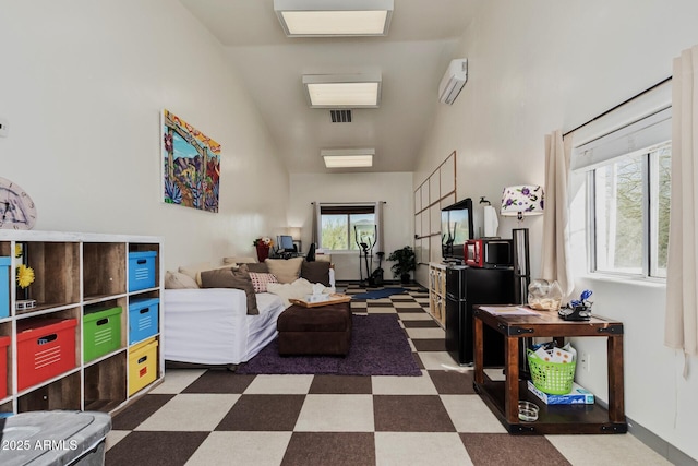 living area with a wall mounted AC and tile patterned floors