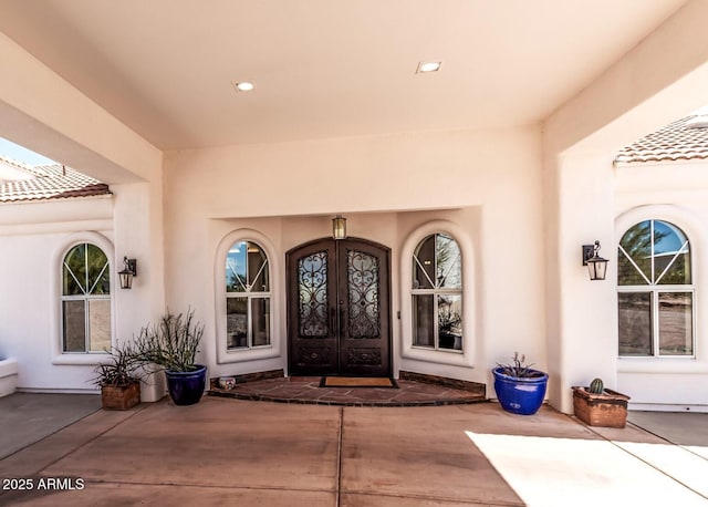 property entrance featuring french doors and stucco siding