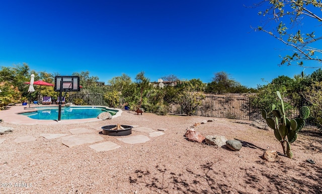 view of pool with a fenced in pool, a fire pit, fence, and a patio