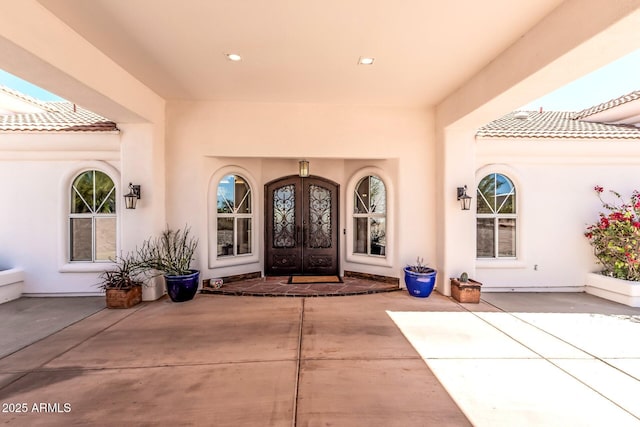 doorway to property featuring french doors and stucco siding