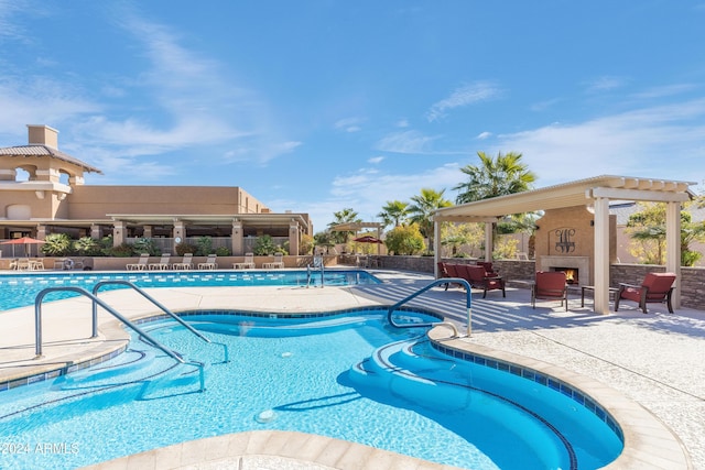 view of swimming pool featuring a patio area and an outdoor fireplace