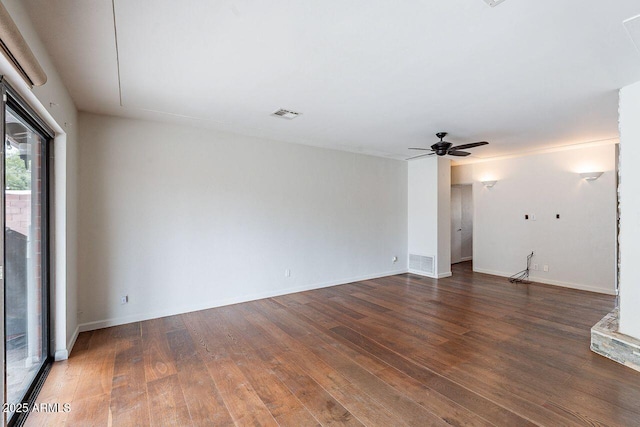 empty room with visible vents, baseboards, a ceiling fan, and wood finished floors