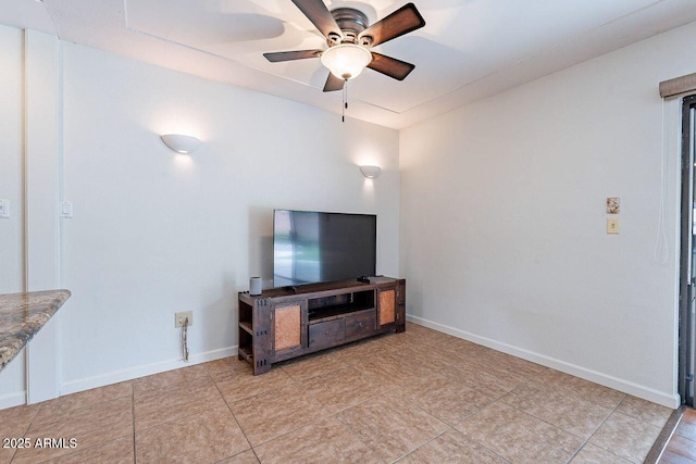 living room with baseboards and ceiling fan