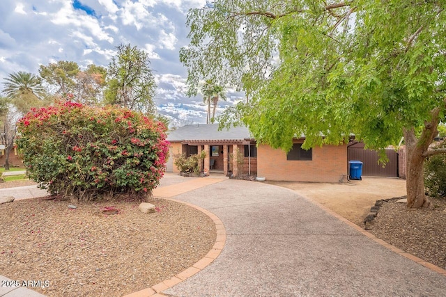 view of front of house with a pergola, brick siding, and a patio