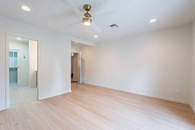 unfurnished room with ceiling fan, baseboards, visible vents, and light wood-type flooring