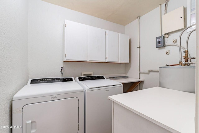 laundry area featuring washer and dryer, cabinet space, and a textured wall