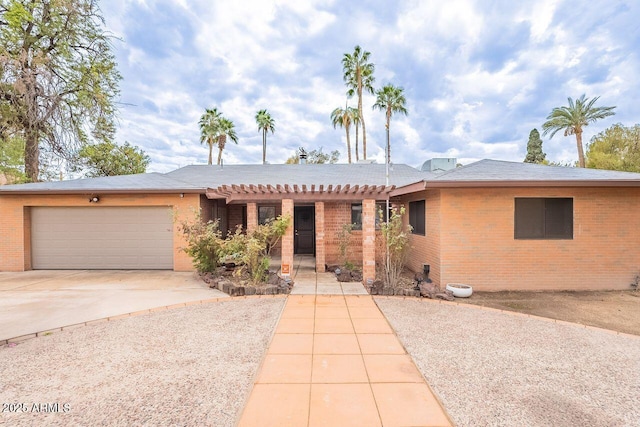 single story home with brick siding, driveway, a pergola, and a garage