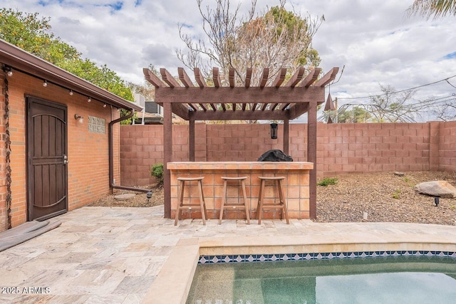 view of swimming pool featuring outdoor dry bar, a fenced in pool, fence, a patio area, and a pergola