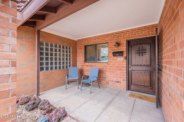 view of exterior entry with brick siding