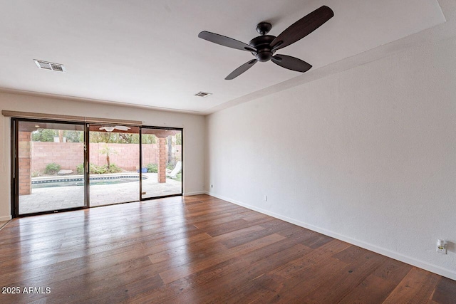 spare room with visible vents, ceiling fan, baseboards, and wood-type flooring