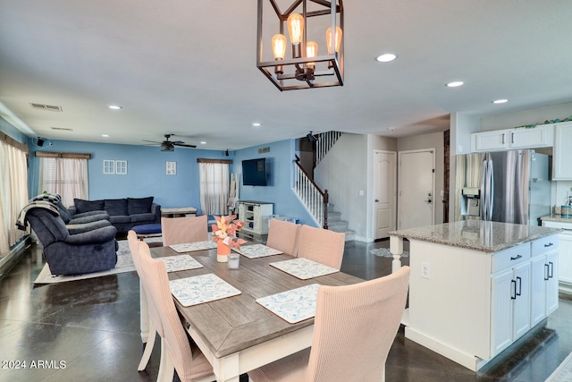 dining area with ceiling fan with notable chandelier