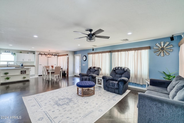 living room featuring ceiling fan and a textured ceiling