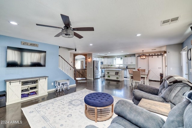 living room featuring ceiling fan with notable chandelier