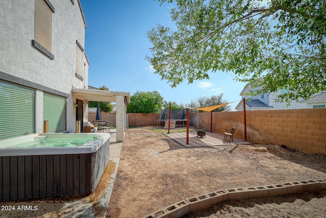 view of yard with central air condition unit, a hot tub, and a trampoline