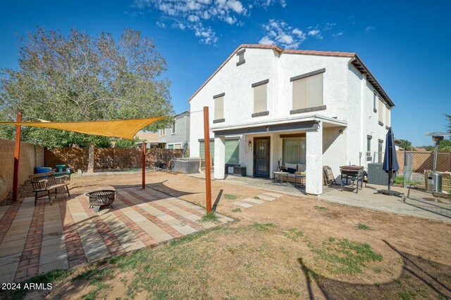 back of property featuring an outdoor fire pit and a patio area