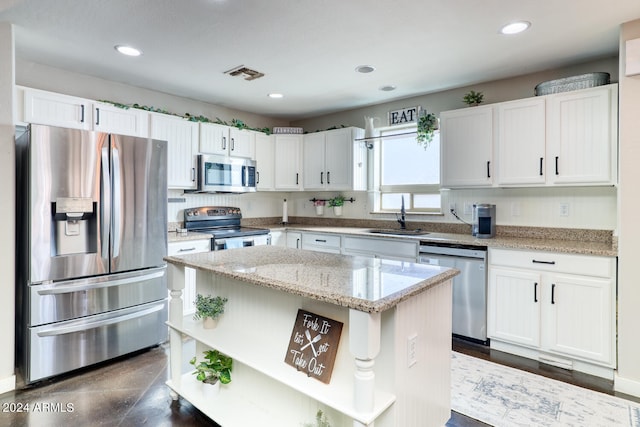 kitchen with white cabinetry, sink, a kitchen island, and stainless steel appliances