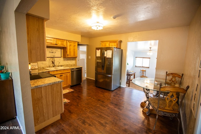 kitchen with appliances with stainless steel finishes, a textured ceiling, dark hardwood / wood-style flooring, decorative backsplash, and ceiling fan