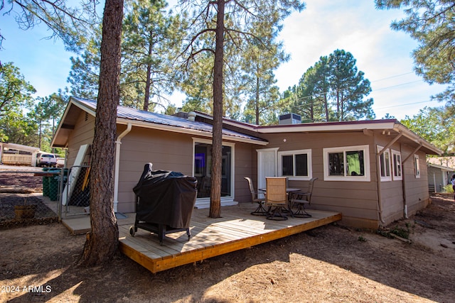 rear view of property featuring a wooden deck