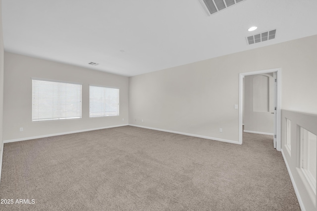 empty room with baseboards, visible vents, and light colored carpet