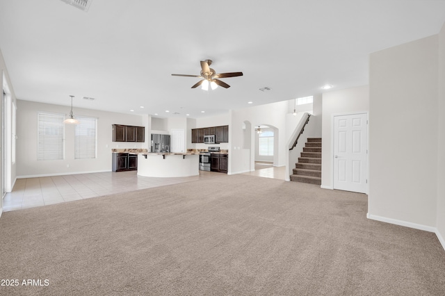 unfurnished living room featuring visible vents, a ceiling fan, light colored carpet, stairway, and recessed lighting