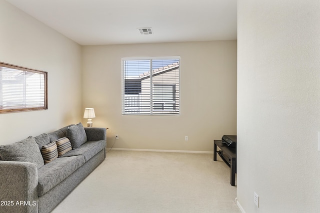 living area with baseboards, visible vents, and light colored carpet