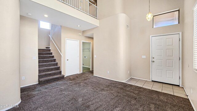 1909 N 106th Ave, Avondale, AZ 85392 - entryway with baseboards, carpet floors, stairway, a towering ceiling, and tile patterned flooring