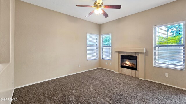 1909 N 106th Ave, Avondale, AZ 85392 - unfurnished living room with a healthy amount of sunlight, ceiling fan, a fireplace, and carpet floors
