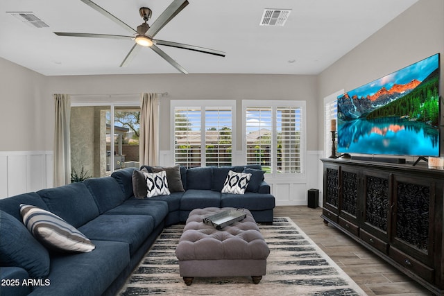 3915 N Shannon Cir, Mesa, AZ 85215 - living area featuring wainscoting, wood finished floors, a ceiling fan, and a decorative wall