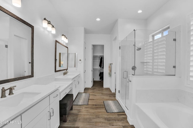3915 N Shannon Cir, Mesa, AZ 85215 - bathroom featuring a shower stall, double vanity, a garden tub, wood finished floors, and a walk in closet