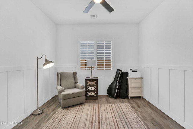 3915 N Shannon Cir, Mesa, AZ 85215 - sitting room featuring wood finished floors, a ceiling fan, a wainscoted wall, and a decorative wall