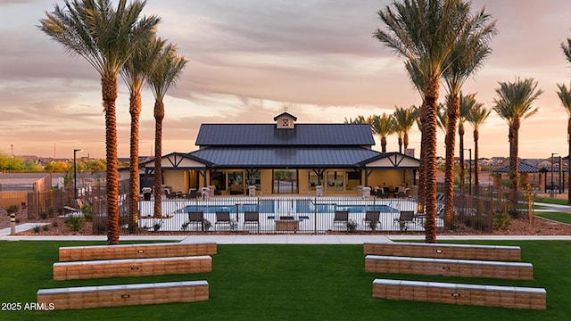 3915 N Shannon Cir, Mesa, AZ 85215 - back of house at dusk featuring a community pool, a patio area, a standing seam roof, and a metal roof