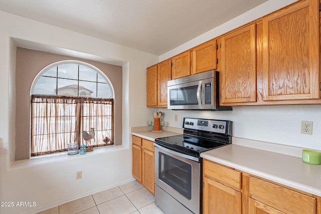 kitchen with light tile patterned flooring and stainless steel appliances