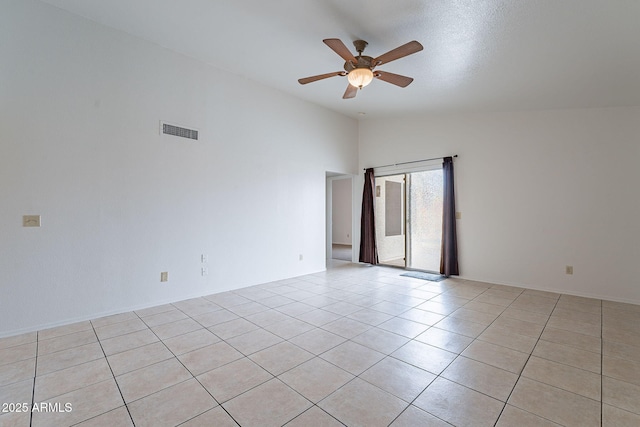 tiled spare room featuring vaulted ceiling and ceiling fan