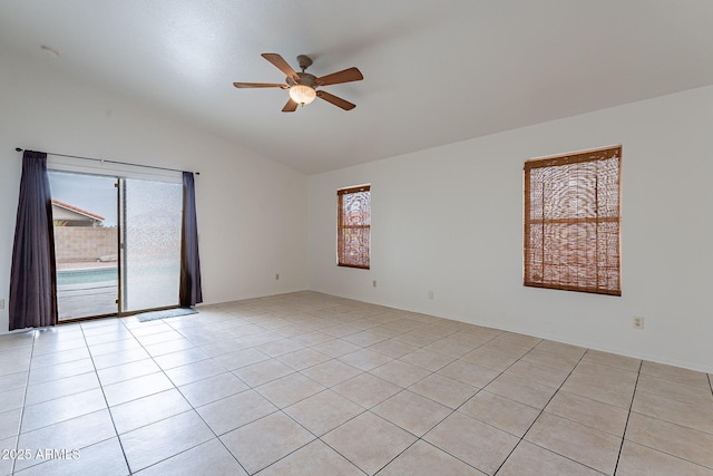 tiled spare room with vaulted ceiling and ceiling fan