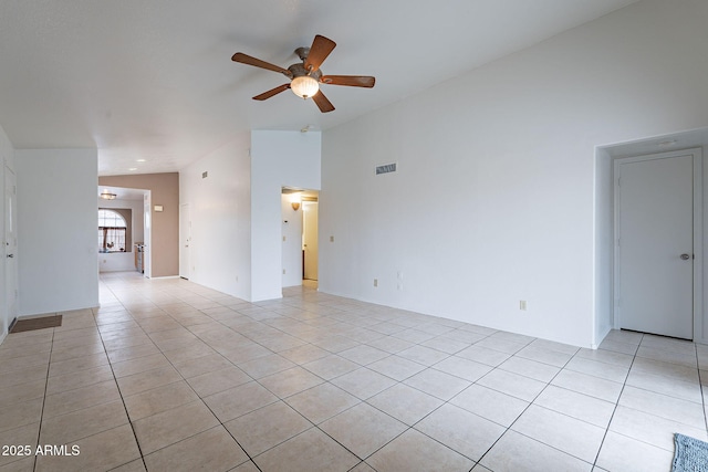 tiled empty room with vaulted ceiling and ceiling fan