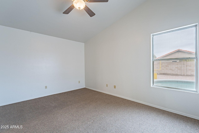 carpeted spare room featuring lofted ceiling and ceiling fan